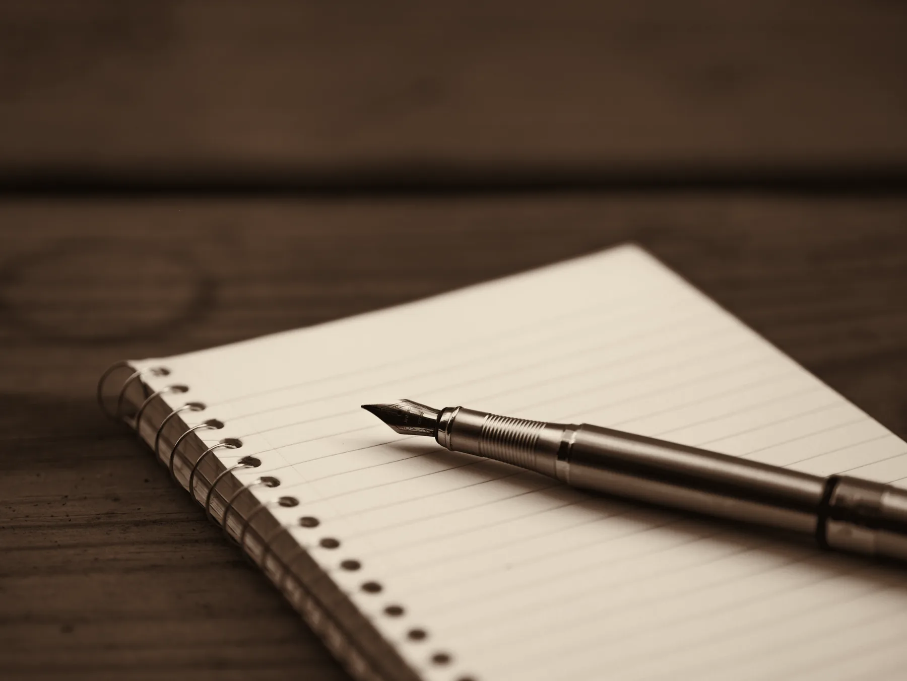 A fountain pen resting on an open notebook